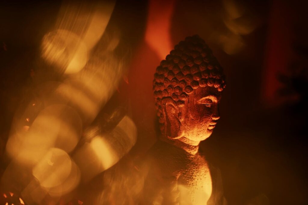 A peaceful Buddha statue illuminated by warm, golden light, exuding spirituality.